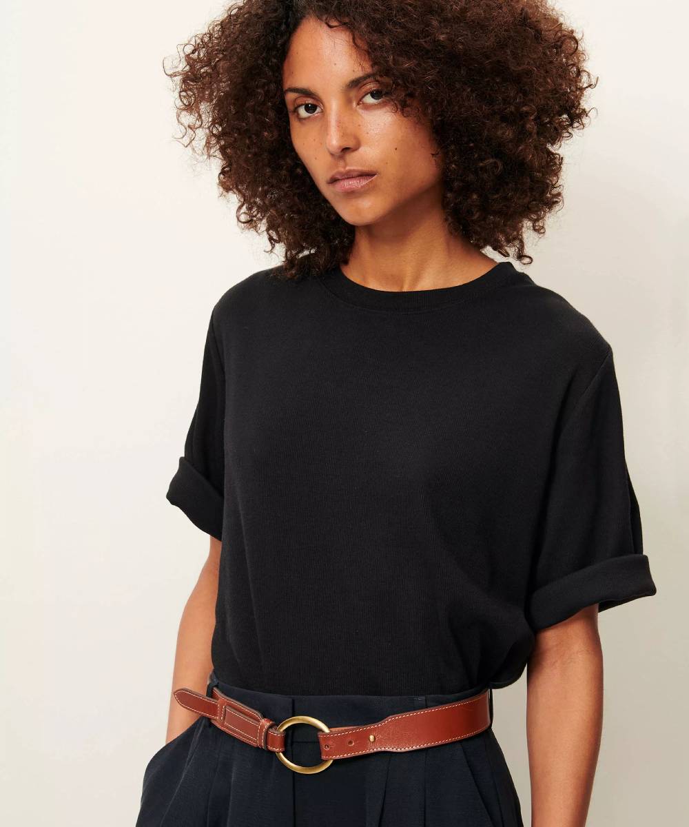 Imagen de modelo llevando una camiseta negra, acanalada, con mangas holgadas y con dobladillo. La Folie Santander.