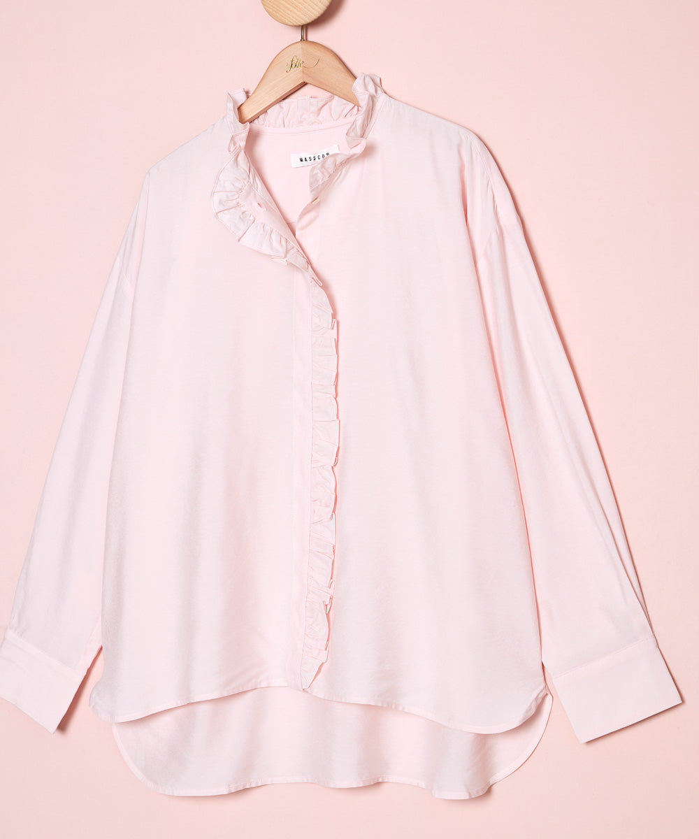 Detalle del tejido de una camisa en color rosa con el cuello redondo y volante festoneado. La Folie Santander.