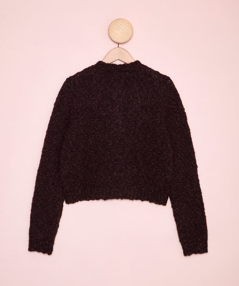 Foto de la espalda de una chaqueta de lana de corte crop y manga larga en color marrón oscuro. Es de la marca Masscob. La Folie Santander.