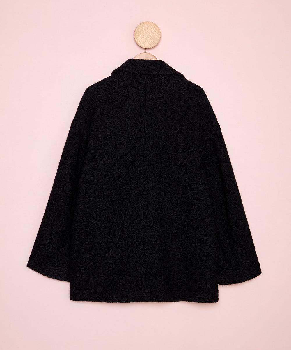 Detalle de la espalda de un chaquetón negro de estilo marinero de corte recto confeccionado en tejido de lana 100%. La Folie Santander.