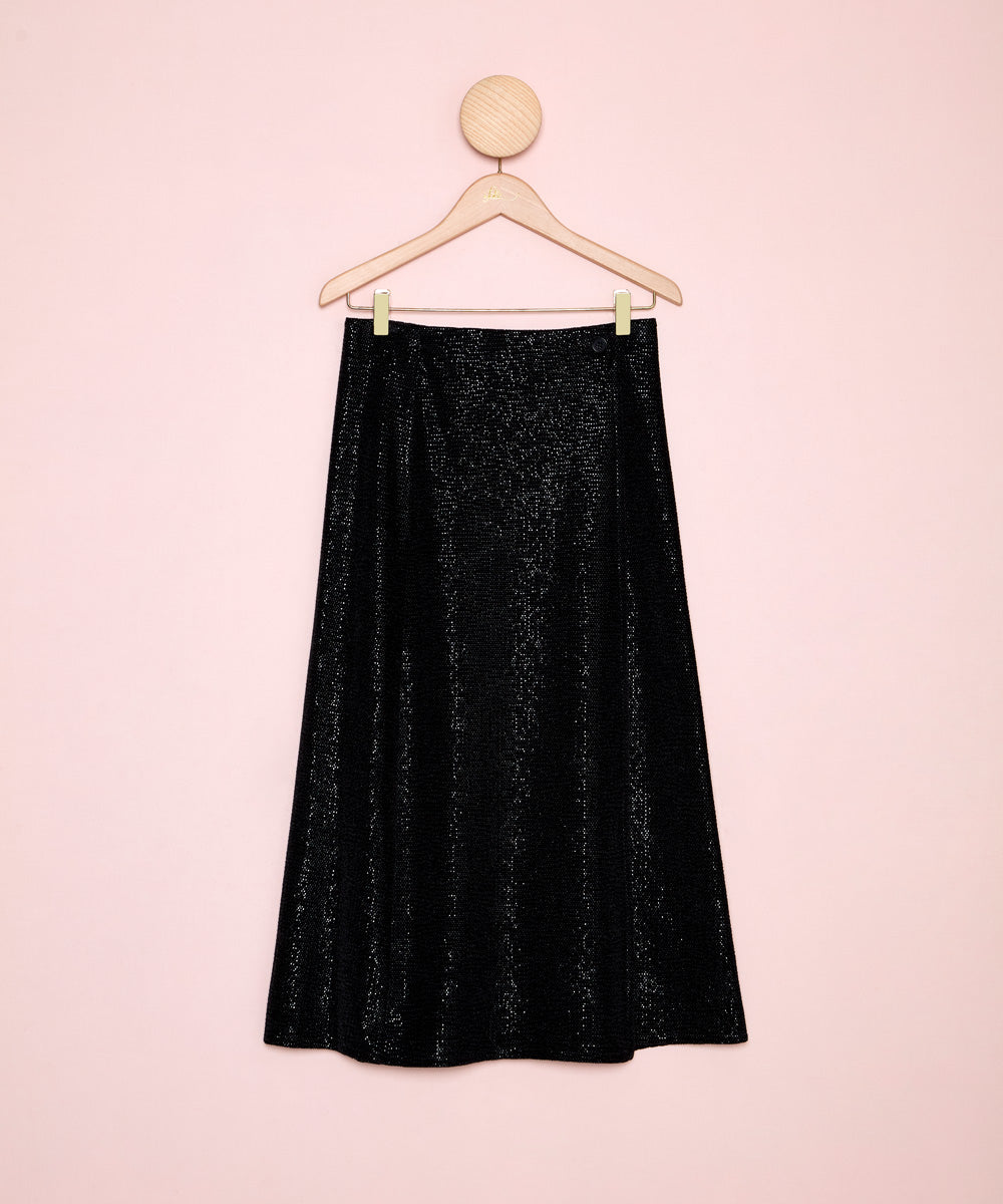 Vista frontal de una falda de fiesta, en color negro y con brillo plateado. Diseño con caída natural y fluida. La Folie Santander.