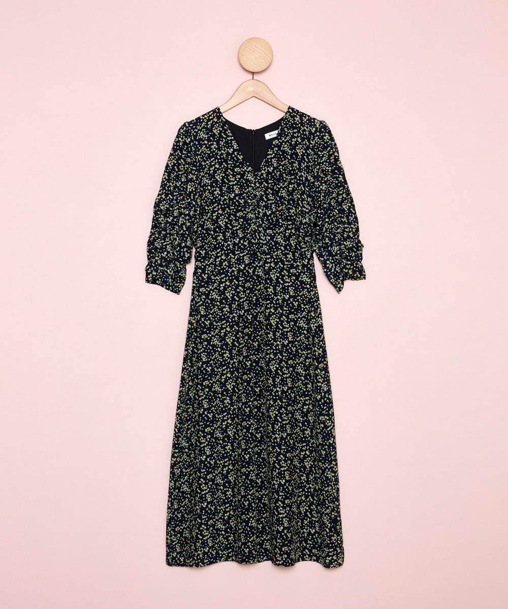 Vista frontal de un vestido estampado con el fondo negro. Diseño con escote en pico y cintura fruncida. La Folie Santander.